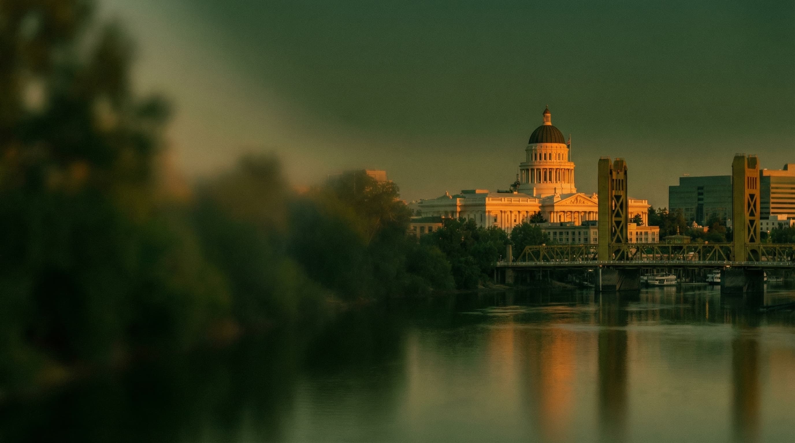 Sacramento Capitol and Tower Bridge at dusk over the river